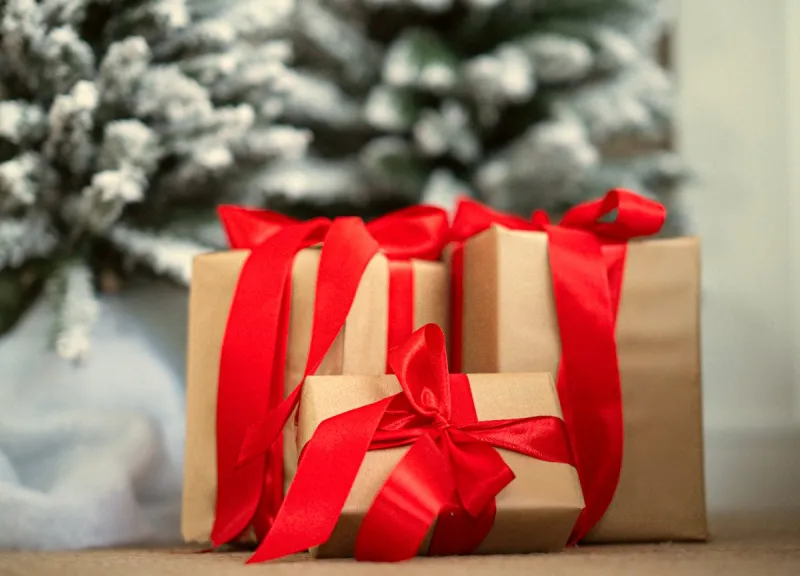 Cadeautjes met rode strikken onder de kerstboom