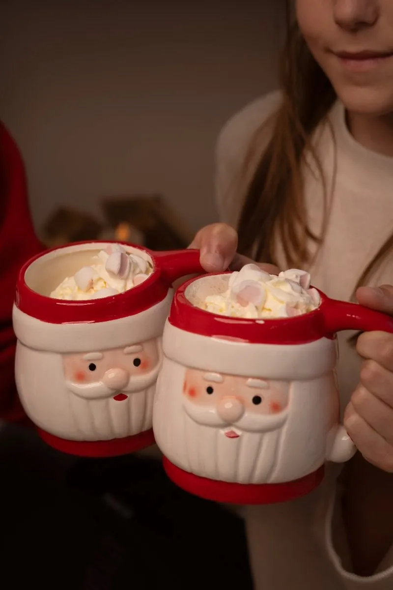 Twee kerstman-mokken met warme chocolademelk